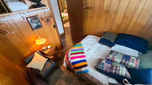 bedroom with wooden walls and dark wood-type flooring