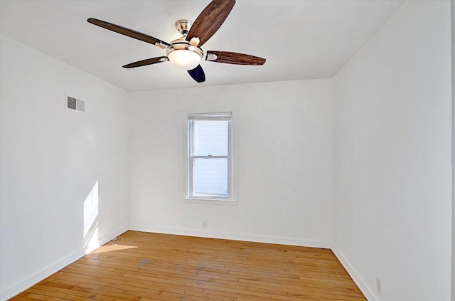 spare room featuring visible vents, ceiling fan, light wood-style flooring, and baseboards