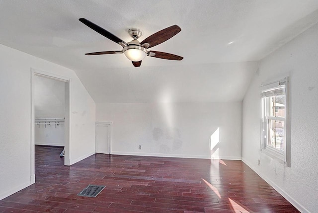 bonus room with lofted ceiling, visible vents, dark wood finished floors, and baseboards