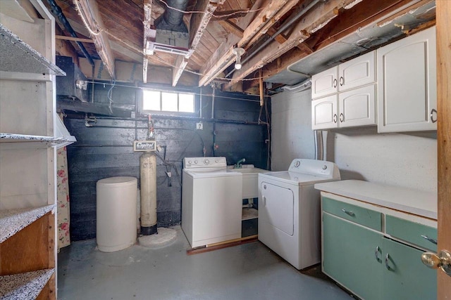 washroom featuring cabinet space, a sink, and washer and clothes dryer