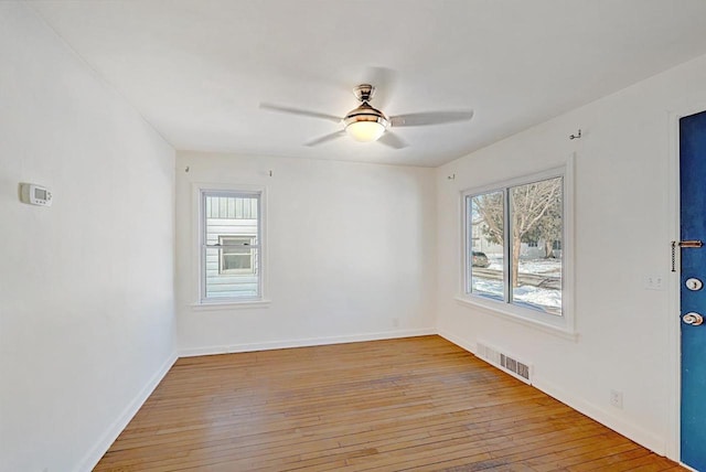 unfurnished room featuring a ceiling fan, visible vents, plenty of natural light, and light wood finished floors