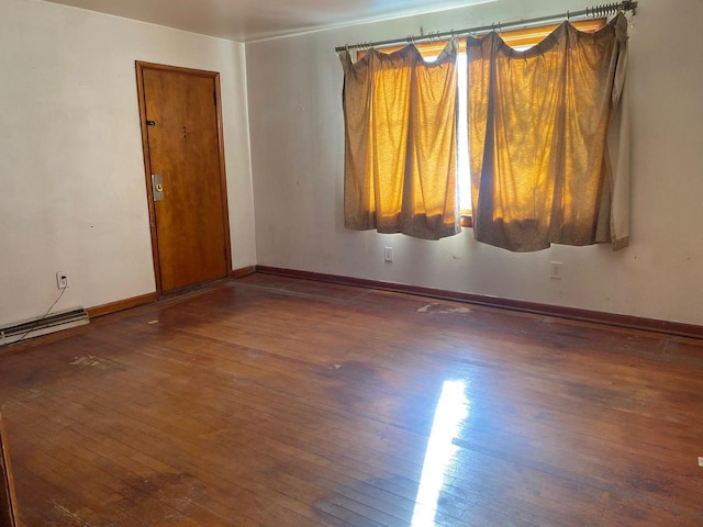 unfurnished room with dark wood-type flooring and baseboards