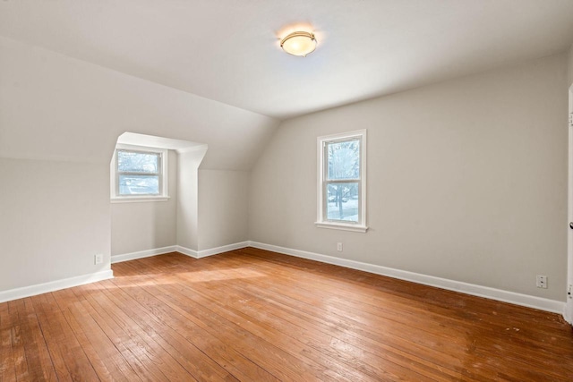 additional living space with vaulted ceiling, baseboards, and wood finished floors