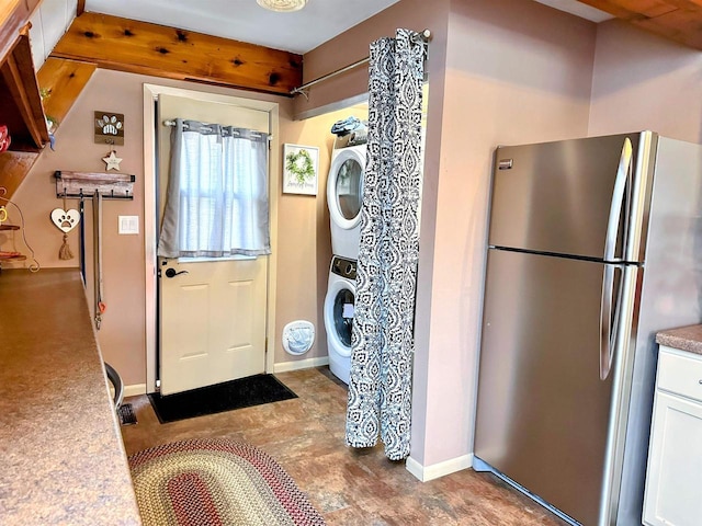 laundry area featuring stacked washer and dryer, laundry area, and baseboards