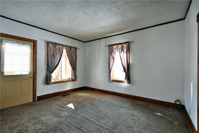 carpeted empty room featuring ornamental molding, visible vents, a textured ceiling, and baseboards