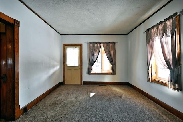 interior space with ornamental molding, carpet flooring, a textured ceiling, and baseboards