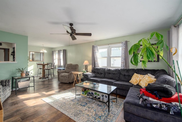 living room featuring dark wood finished floors, a ceiling fan, and a healthy amount of sunlight