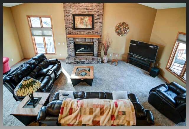 living room with carpet flooring, a fireplace, and vaulted ceiling