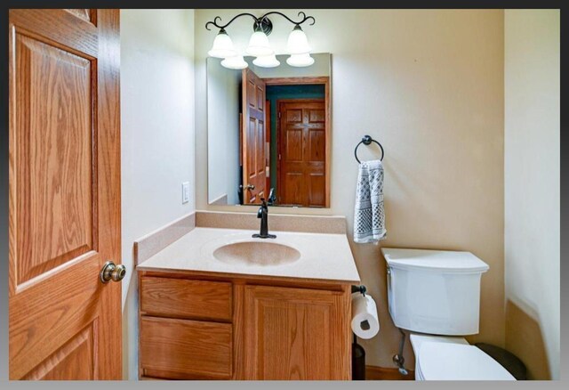 half bath featuring toilet and vanity