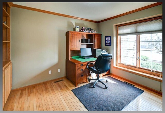 office with visible vents, baseboards, light wood-style floors, and ornamental molding