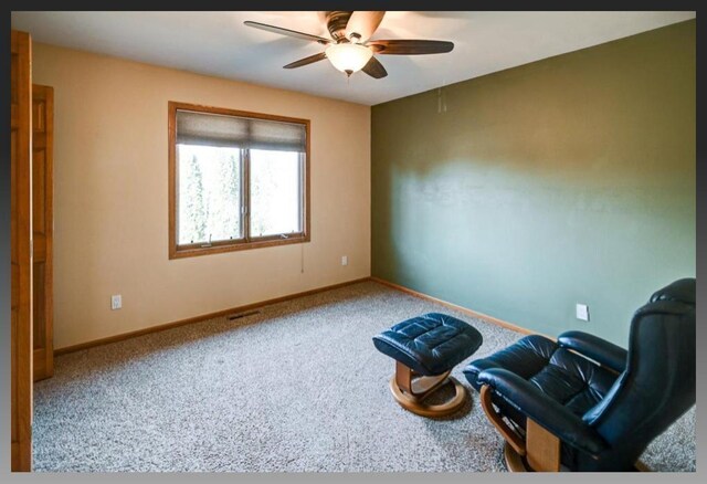 living area featuring ceiling fan, baseboards, and carpet