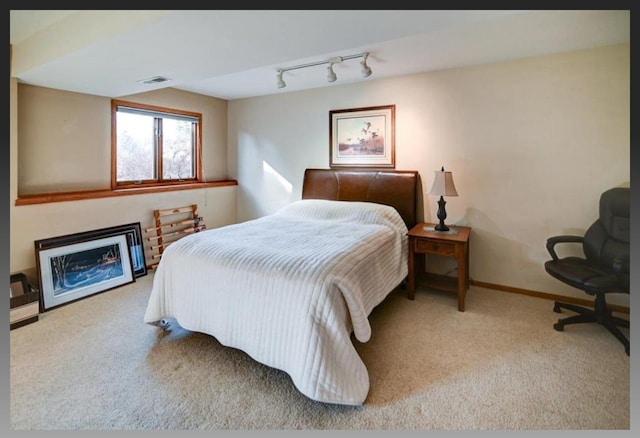 bedroom with visible vents, baseboards, carpet, and rail lighting