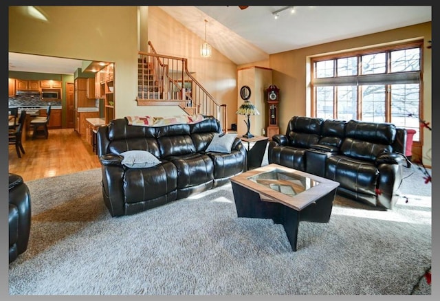 living room featuring stairs, lofted ceiling, and wood finished floors