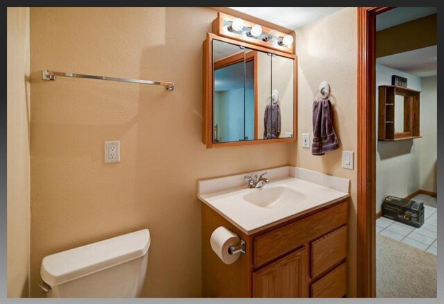 bathroom featuring tile patterned floors, toilet, and vanity