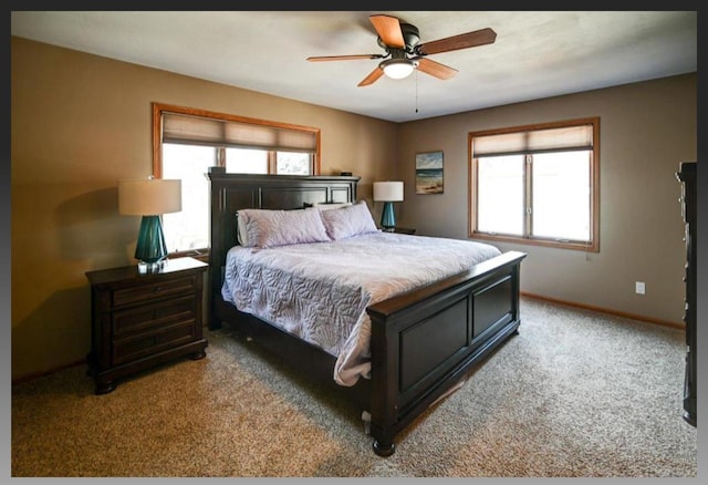 bedroom featuring baseboards, multiple windows, light carpet, and a ceiling fan