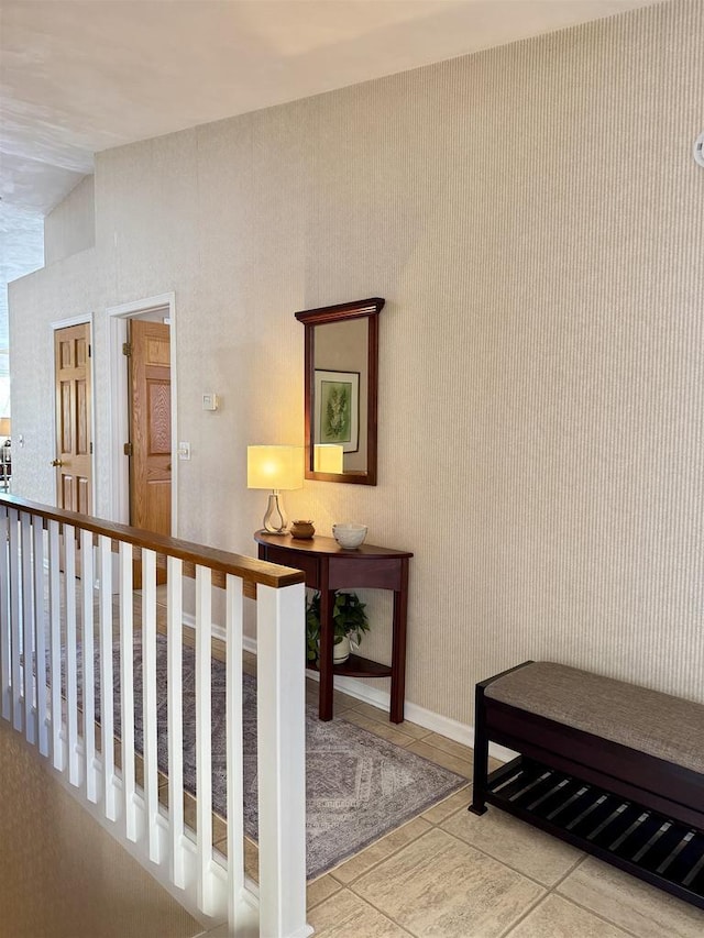 corridor with baseboards and tile patterned floors