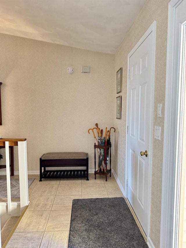 interior space with wallpapered walls, baseboards, and light tile patterned flooring