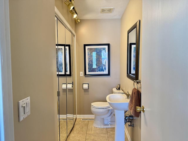 bathroom with toilet, tile patterned flooring, visible vents, and baseboards