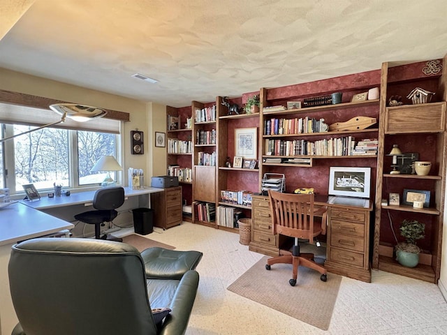 office space featuring a textured ceiling, built in study area, and visible vents