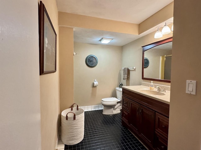 bathroom with a shower with door, toilet, vanity, baseboards, and tile patterned floors