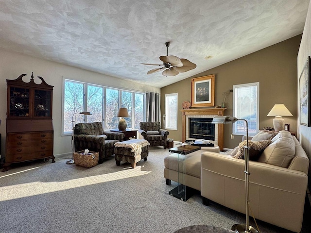 living area featuring lofted ceiling, a glass covered fireplace, a textured ceiling, and light colored carpet