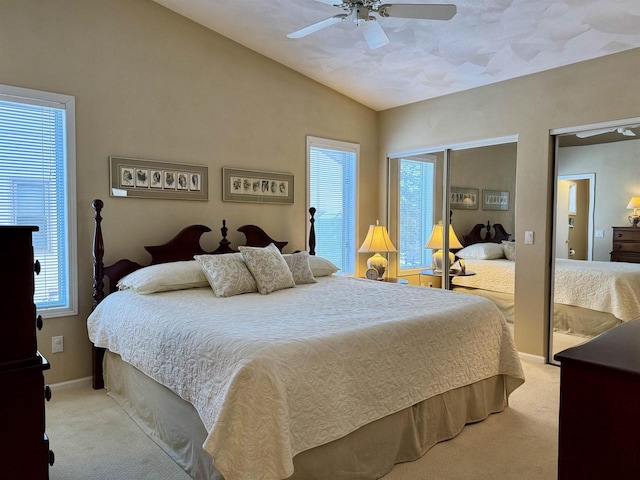 bedroom featuring light carpet, baseboards, vaulted ceiling, and a ceiling fan