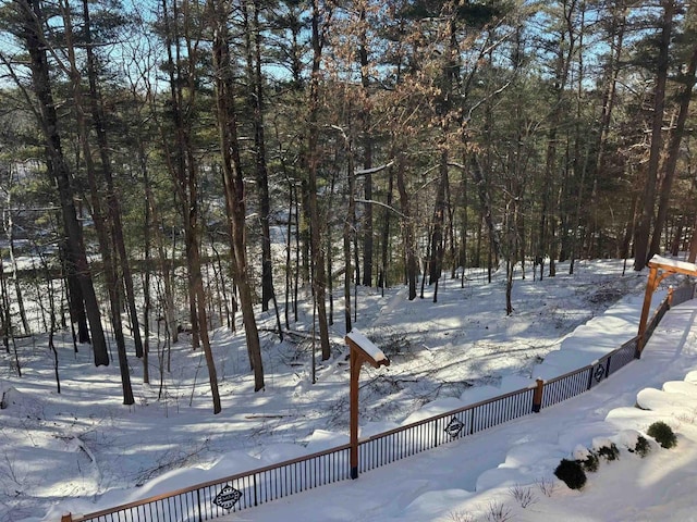 snowy yard featuring fence