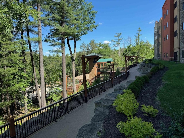 view of home's community featuring a playground and fence