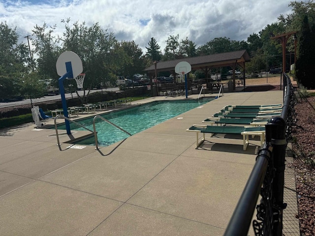 pool featuring fence and a patio