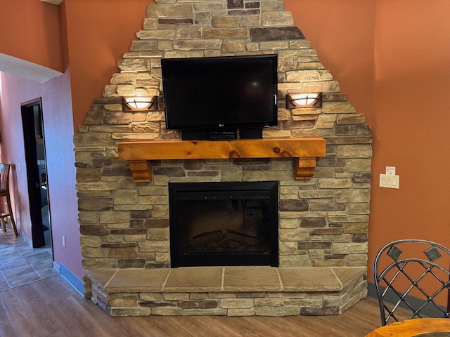 details featuring a fireplace, wood finished floors, and baseboards