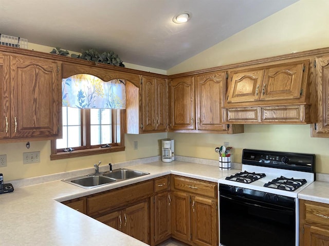 kitchen with brown cabinetry, range with gas cooktop, vaulted ceiling, light countertops, and a sink