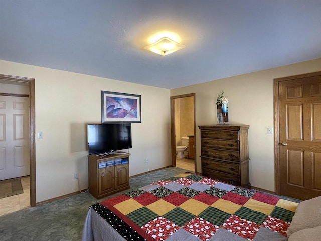 bedroom with dark colored carpet, connected bathroom, and baseboards