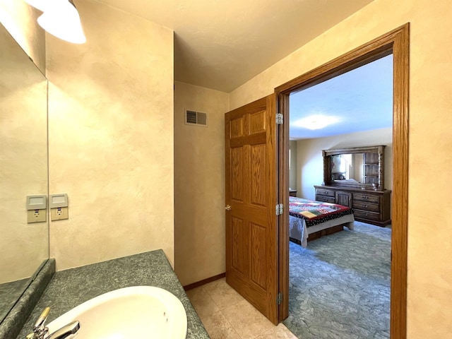 bathroom featuring visible vents, baseboards, ensuite bathroom, tile patterned flooring, and vanity