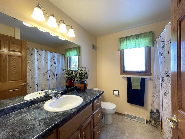 bathroom featuring toilet, vanity, visible vents, and tile patterned floors