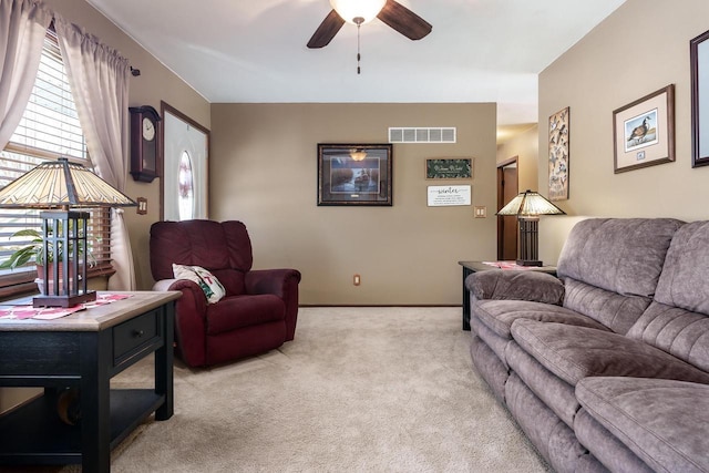 living area with a ceiling fan, baseboards, visible vents, and carpet flooring