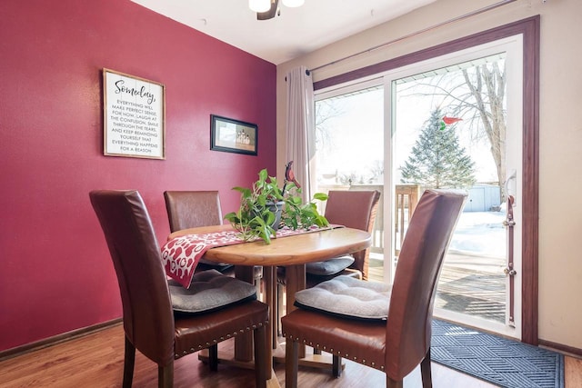 dining space featuring baseboards and wood finished floors