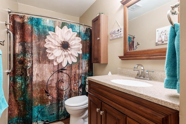 full bathroom with toilet, visible vents, and vanity