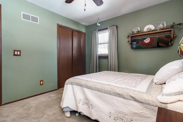 bedroom with a closet, visible vents, light carpet, ceiling fan, and baseboards