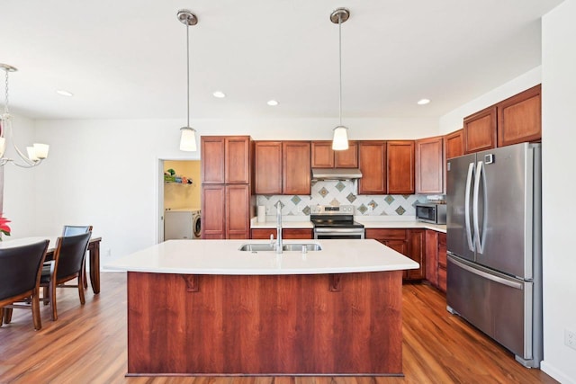 2418 Leopold Way, Sun Prairie, WI 53590 - kitchen with appliances with stainless steel finishes, light countertops, under cabinet range hood, pendant lighting, and a sink