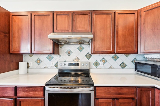 2418 Leopold Way, Sun Prairie, WI 53590 - kitchen with under cabinet range hood, appliances with stainless steel finishes, light countertops, and backsplash