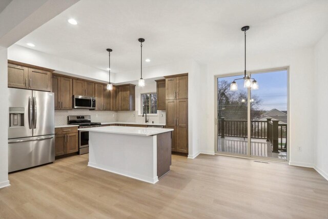 N174W20582 Laurel Springs Cir, Jackson, WI 53037 - kitchen featuring light countertops, appliances with stainless steel finishes, light wood-type flooring, and pendant lighting