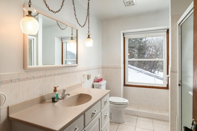 4191 Aspen Ln, La Crescent, MN 55947 - full bath with tile patterned flooring, visible vents, vanity, tile walls, and a shower with door