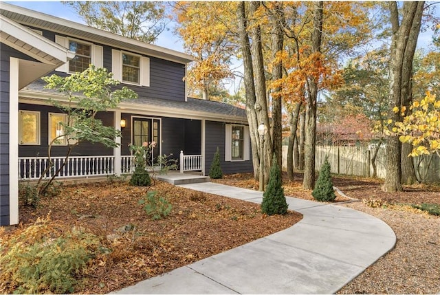 traditional home with covered porch and fence