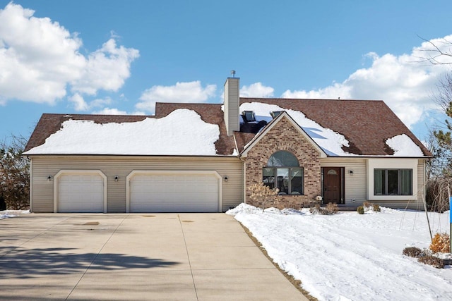 view of front of house with a garage, concrete driveway, brick siding, and a chimney