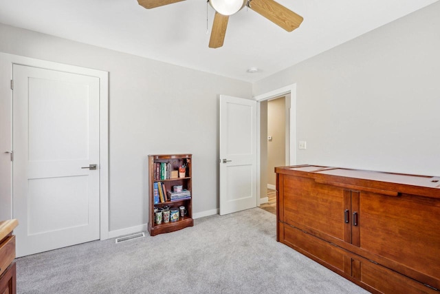 interior space with baseboards, a ceiling fan, visible vents, and light colored carpet