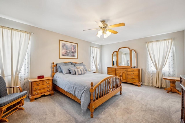 bedroom featuring a ceiling fan and light colored carpet