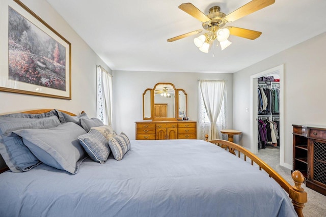 carpeted bedroom featuring ceiling fan, a spacious closet, a closet, and baseboards