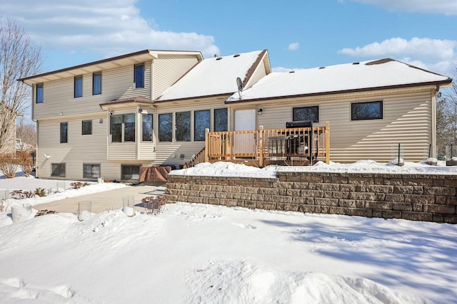 snow covered rear of property featuring a wooden deck