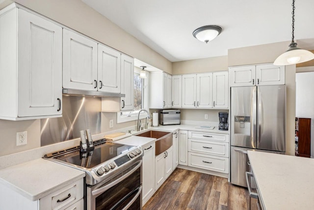 kitchen featuring stainless steel appliances, white cabinets, light countertops, and decorative light fixtures