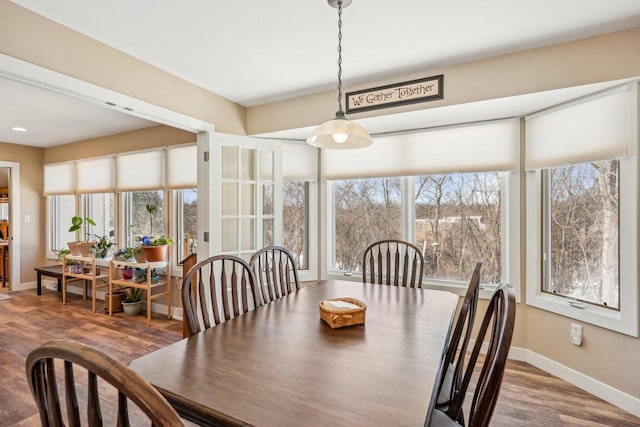 dining area featuring a wealth of natural light, baseboards, and wood finished floors